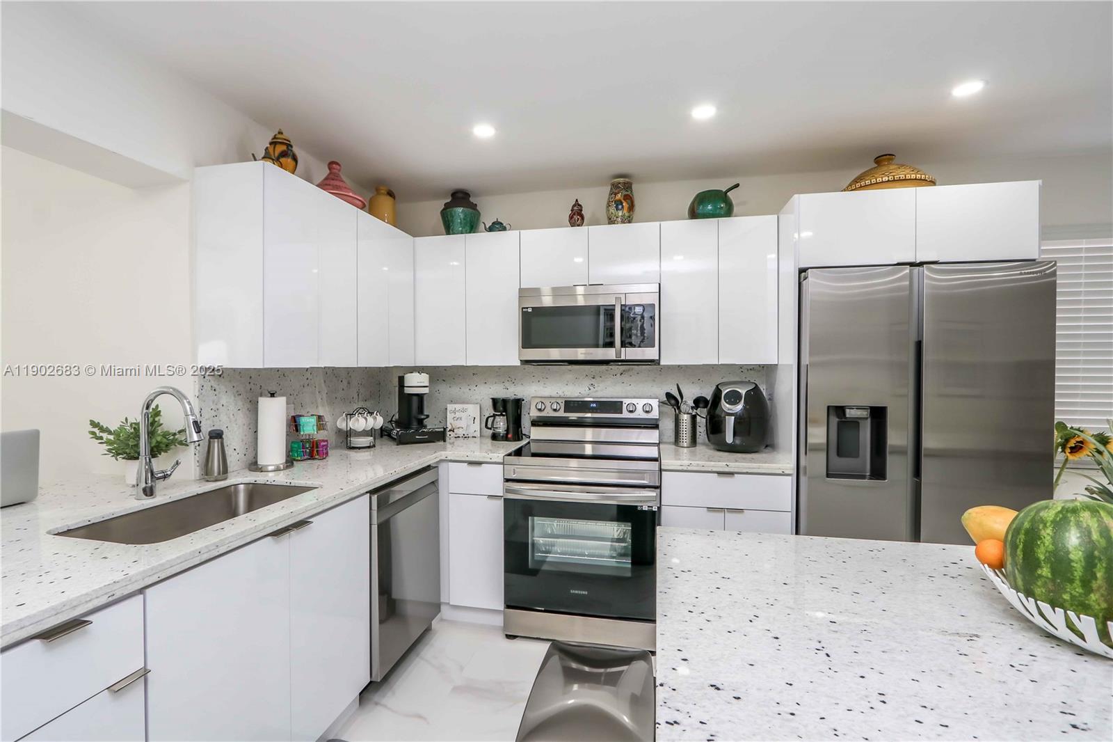 1030 Southwest 10th Avenue Miami, FL 33130 - Photo 11 of 30 a kitchen with white cabinets and stainless steel appliances