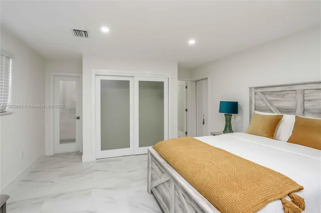 a spacious bedroom with a bed and a cabinets