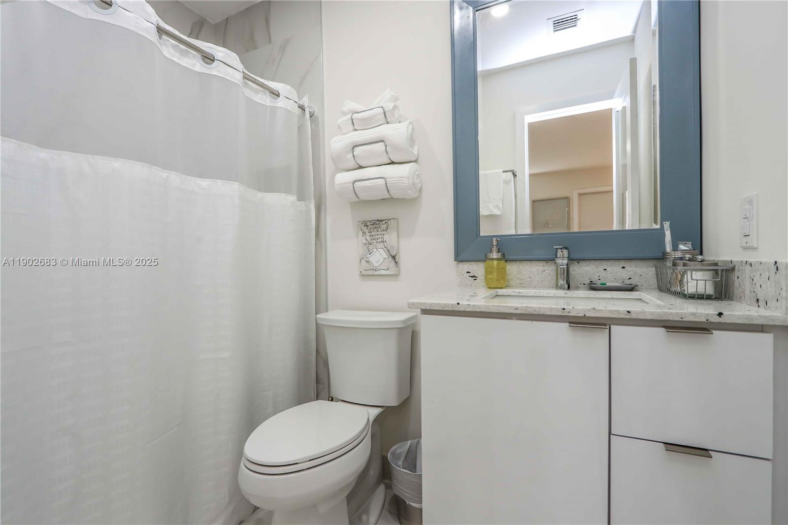 1030 Southwest 10th Avenue Miami, FL 33130 - Photo 20 of 30 a bathroom with a granite countertop toilet a sink and a mirror