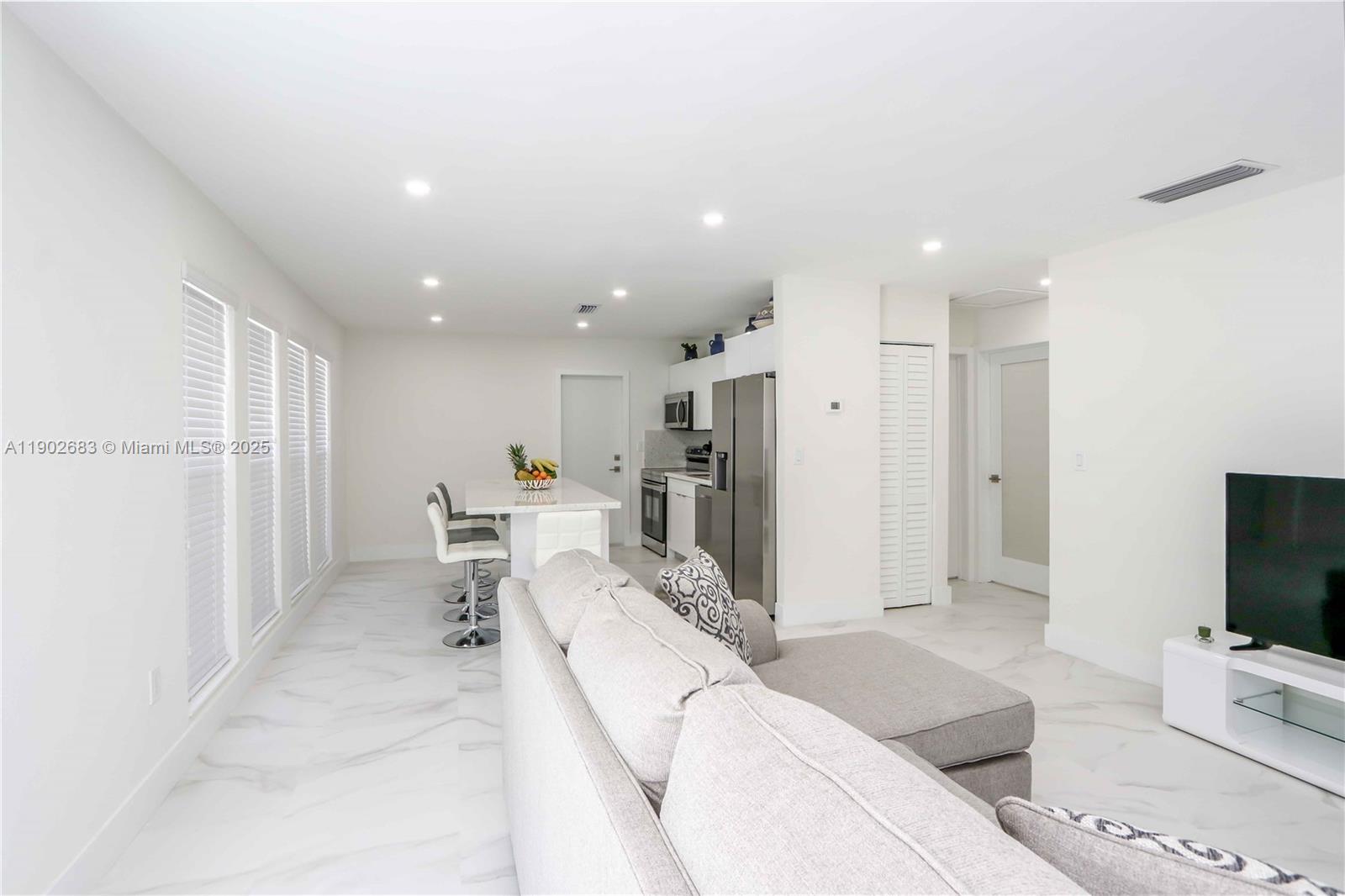 1030 Southwest 10th Avenue Miami, FL 33130 - Photo 24 of 30 a living room with furniture a flat screen tv and a refrigerator