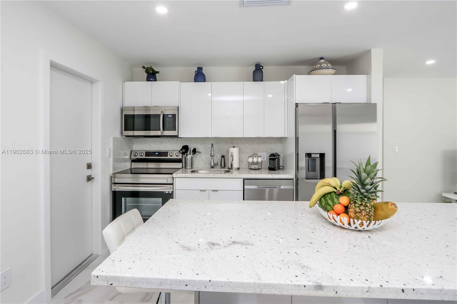 1030 Southwest 10th Avenue Miami, FL 33130 - Photo 26 of 30 a kitchen with stainless steel appliances kitchen island granite countertop a stove and a white cabinets