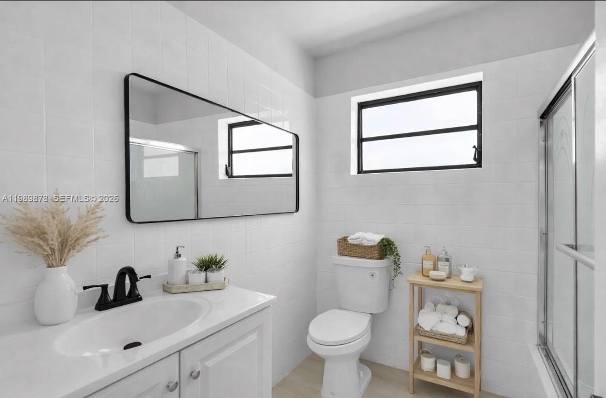 4485 East 8th Avenue Hialeah, FL 33013 - Photo 11 of 26 a bathroom with a toilet sink and mirror