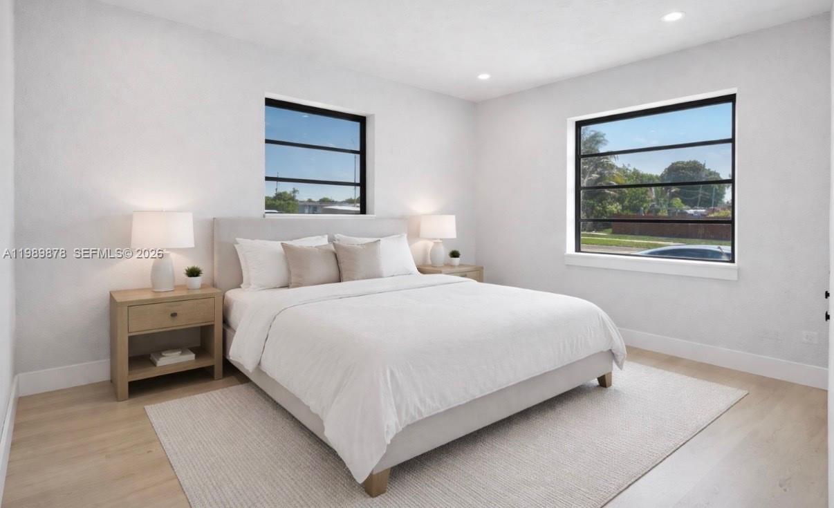 4485 East 8th Avenue Hialeah, FL 33013 - Photo 13 of 26 a bedroom with a bed and a painting on the wall