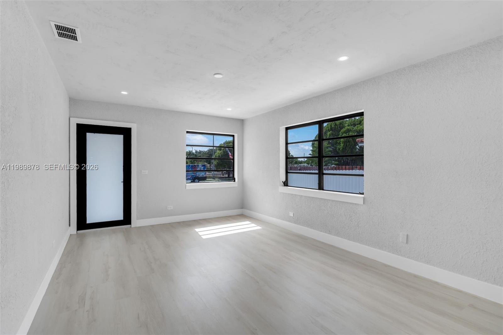 4485 East 8th Avenue Hialeah, FL 33013 - Photo 7 of 26 wooden floor in an empty room with a window