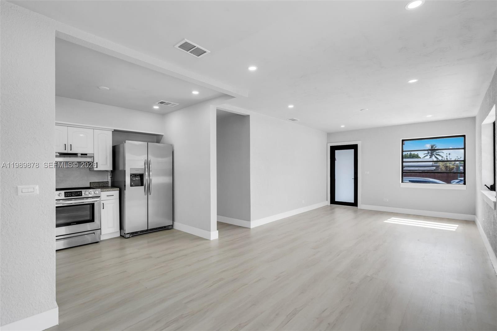 4485 East 8th Avenue Hialeah, FL 33013 - Photo 8 of 26 a view of a kitchen with refrigerator stove and wooden floor