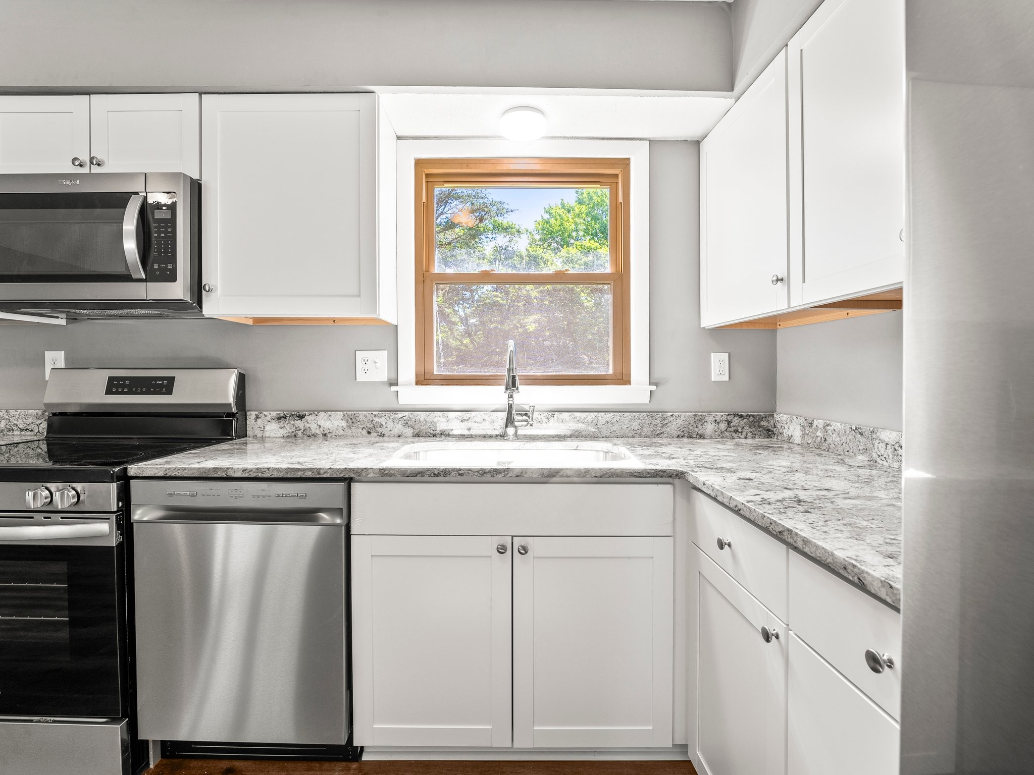 103 Cedar Street Huntland, TN 37345 - Photo 11 of 26 a kitchen with granite countertop a sink stainless steel appliances and white cabinets