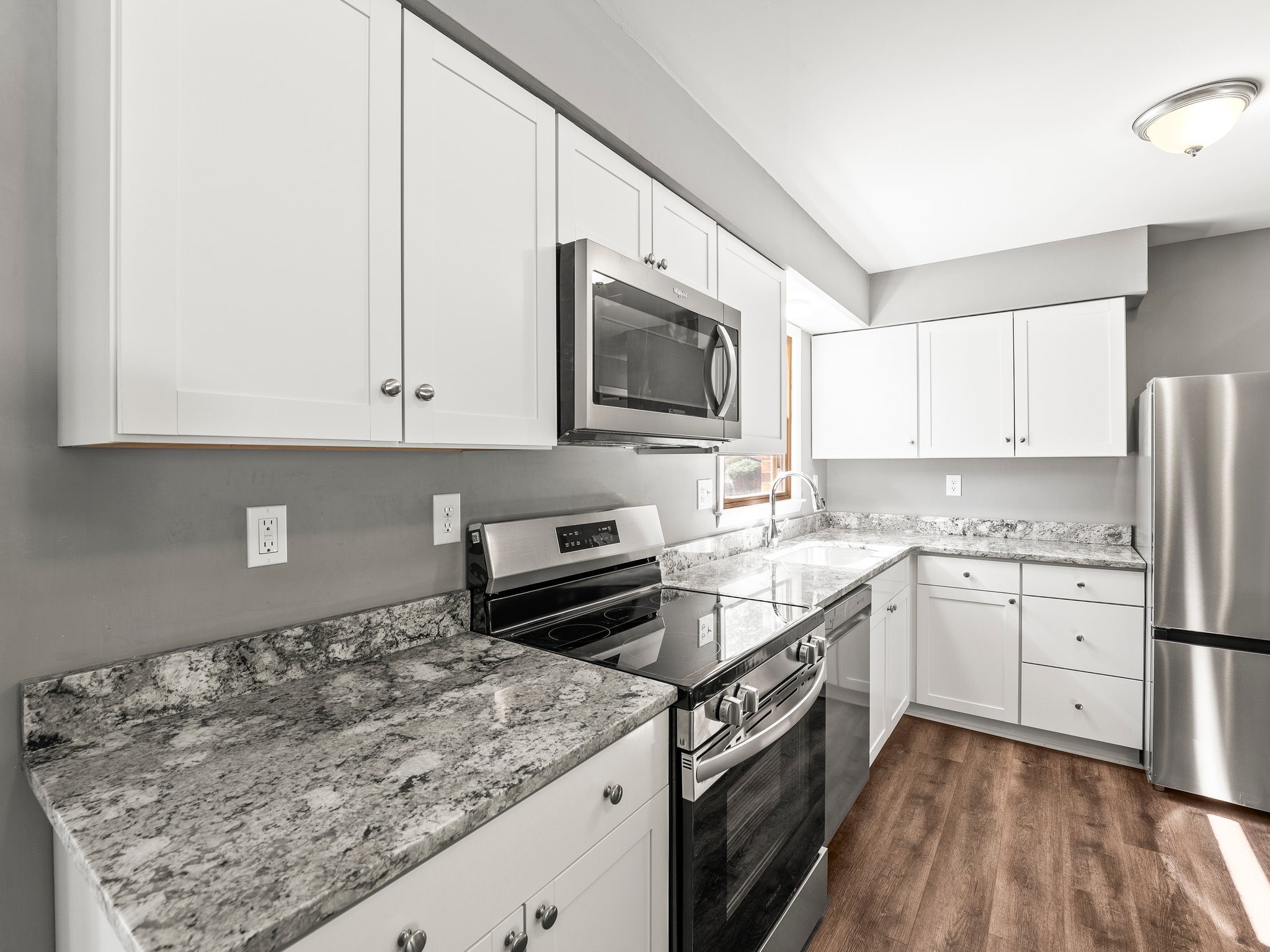 103 Cedar Street Huntland, TN 37345 - Photo 12 of 26 a kitchen with granite countertop a sink a stove top oven and cabinetry