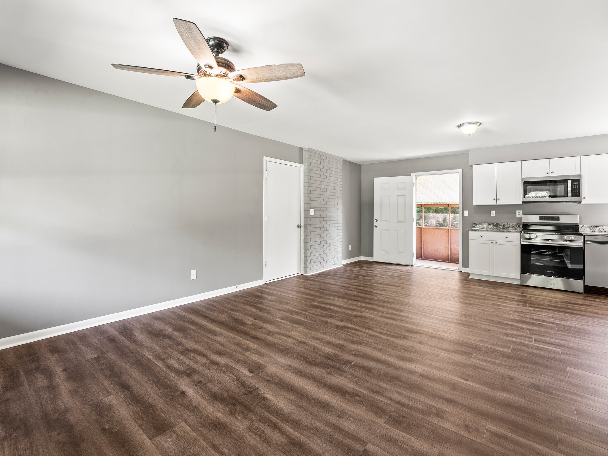 103 Cedar Street Huntland, TN 37345 - Photo 6 of 26 a view of a kitchen with a stove cabinets wooden floor and a ceiling fan
