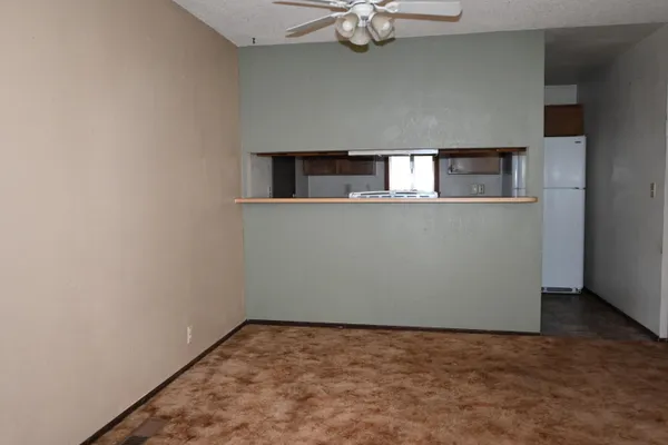 a view of an empty room with a chandelier fan