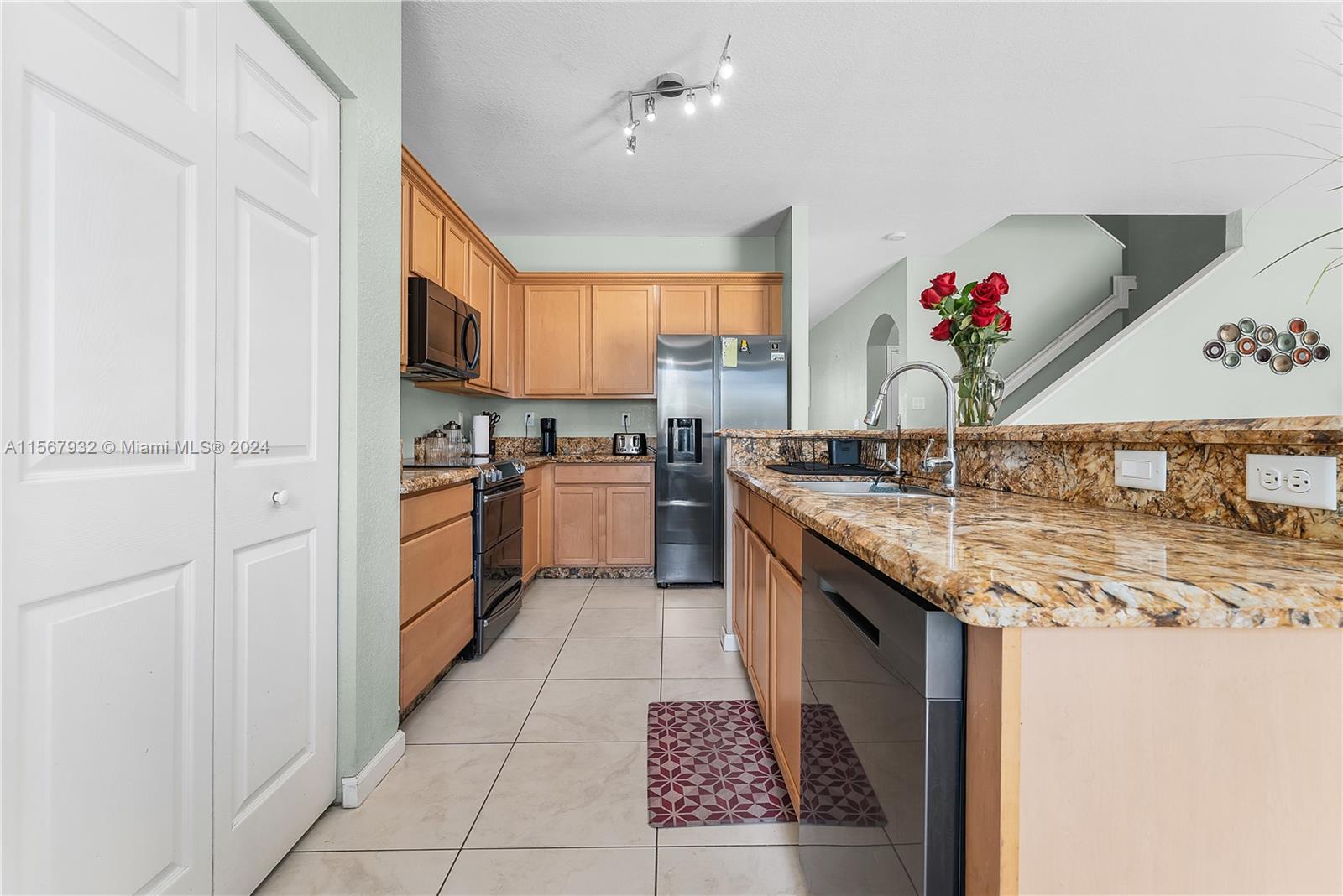 657 Southeast 30th Terrace Homestead, FL 33033 - Photo 12 of 53 a kitchen with stainless steel appliances granite countertop a sink stove and cabinets