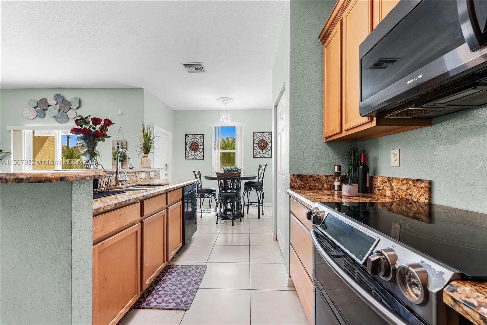 657 Southeast 30th Terrace Homestead, FL 33033 - Photo 13 of 53 a kitchen with stainless steel appliances granite countertop a stove and a sink