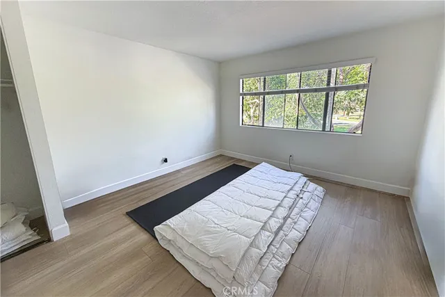 wooden floor in a bedroom next to a window