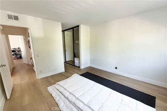 a room with a bed and wooden floor