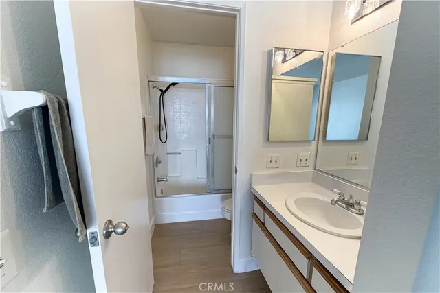 a bathroom with a sink a mirror a vanity and shower