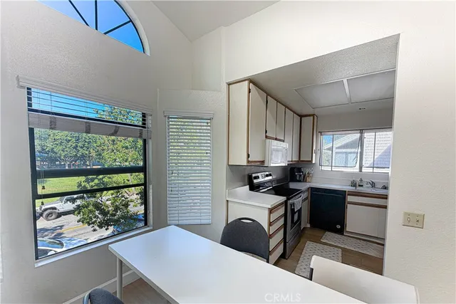 a kitchen with a table chairs sink and cabinets
