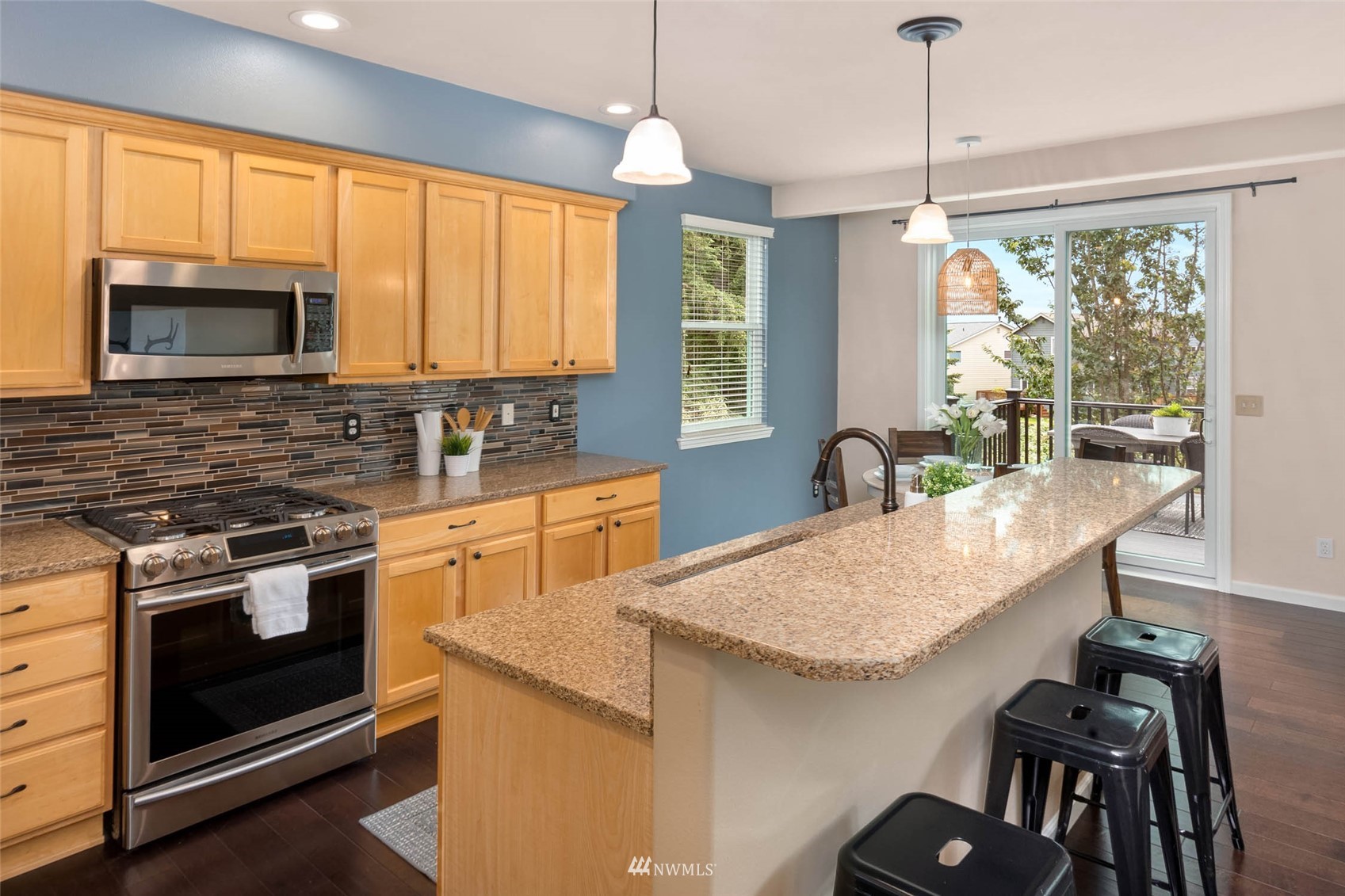 106 202nd Street Southeast Bothell, WA 98012 - Photo 11 of 32 a kitchen with stainless steel appliances granite countertop a stove a sink a microwave a dining table and chairs