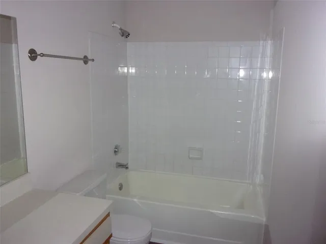 a bathroom with a bathtub shower and toilet