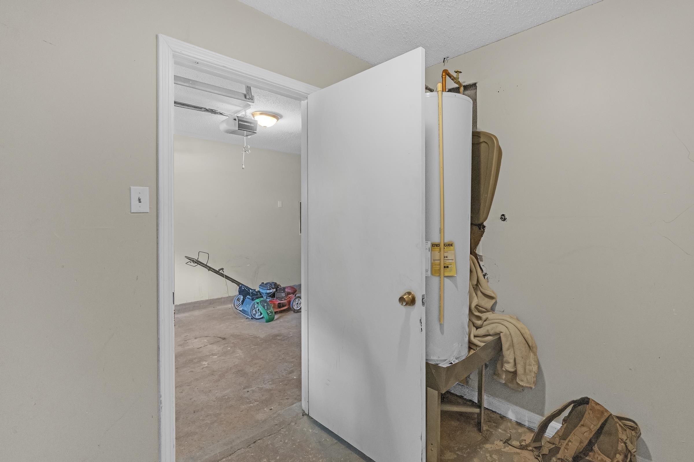 6128 Raintree Drive Memphis, TN 38115 - Photo 29 of 30 Hall with a textured ceiling, concrete flooring, and water heater