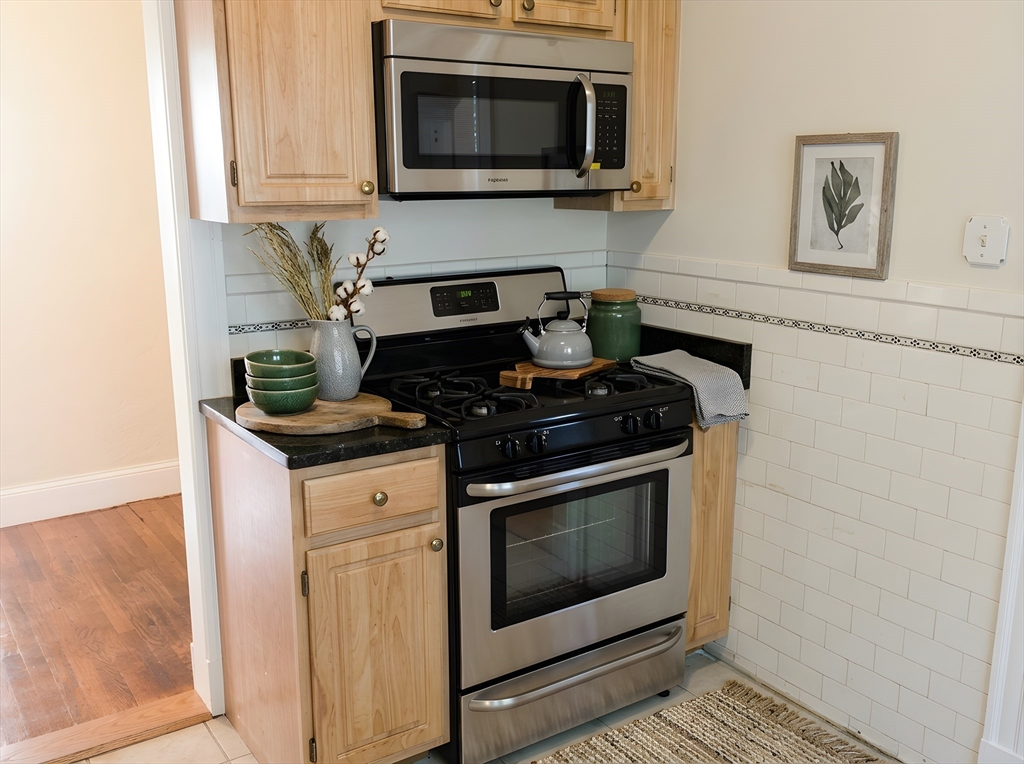 203-205 Winthrop Road, Unit 3 Brookline, MA 02445 - Photo 6 of 9 a kitchen with stainless steel appliances a stove a microwave sink and cabinets