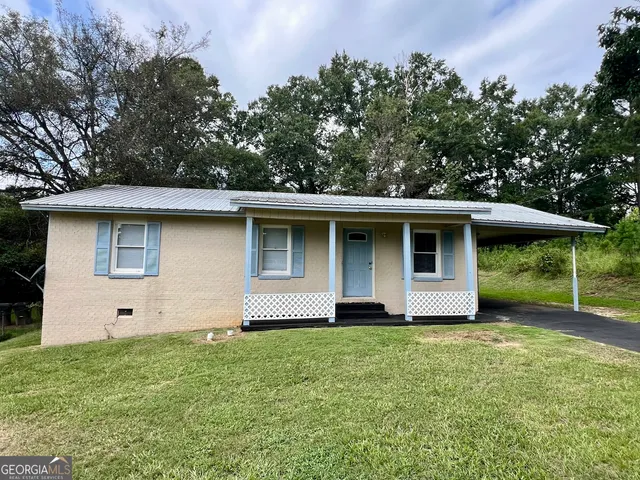 a front view of house with yard and trees