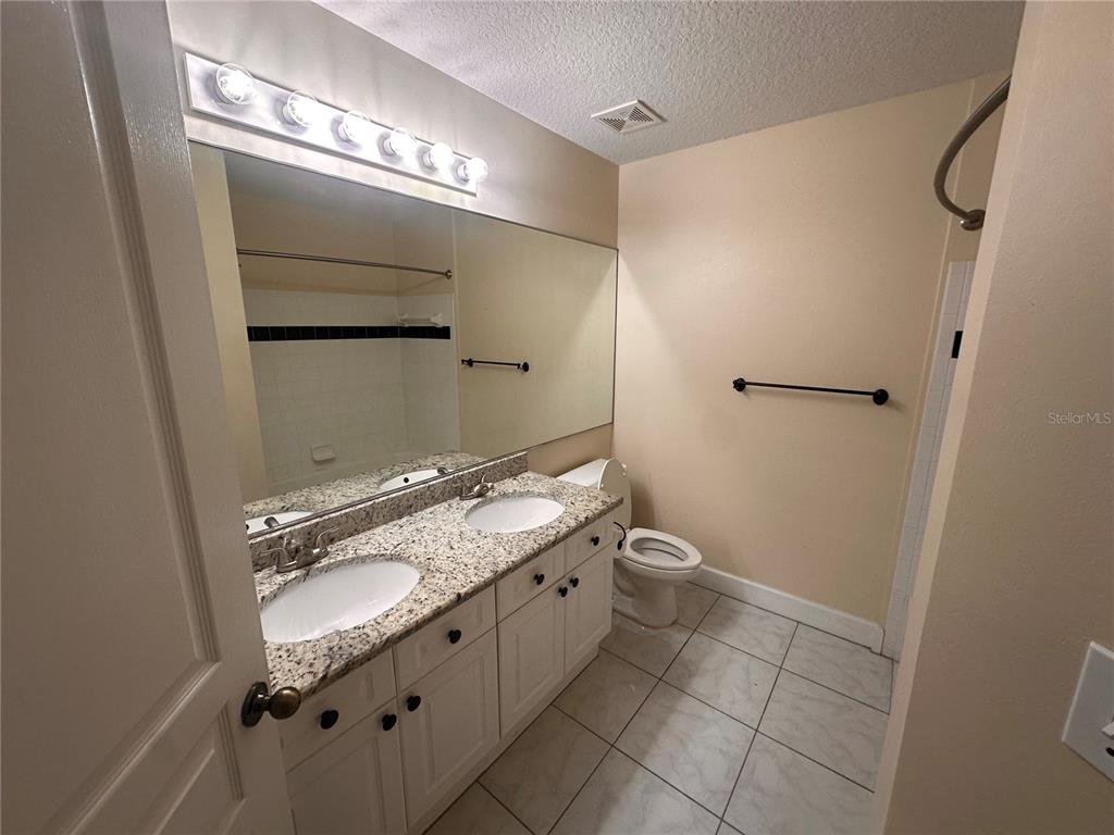 709 Bloom Street, Unit 240 Celebration, FL 34747 - Photo 12 of 17 a bathroom with a granite countertop sink and a mirror