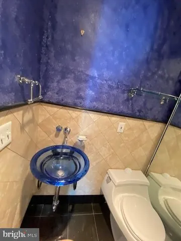a bathroom with a toilet a sink and a mirror