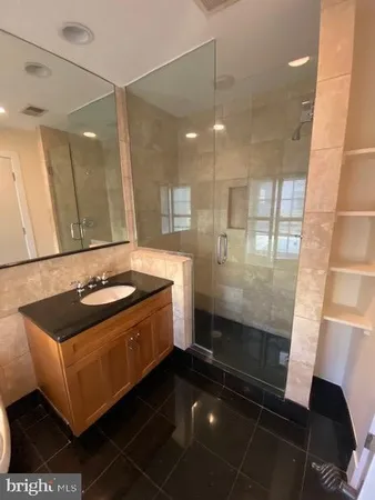 a bathroom with a sink a toilet a mirror and shower
