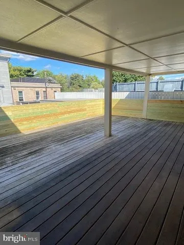 a view of an empty room with wooden floor and a floor to ceiling window