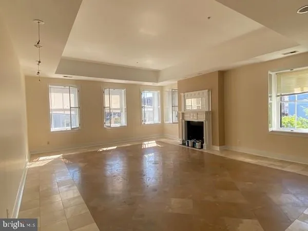 a view of an empty room with a window and fireplace