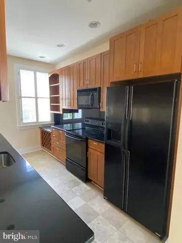 a kitchen with granite countertop stainless steel appliances a refrigerator and a sink