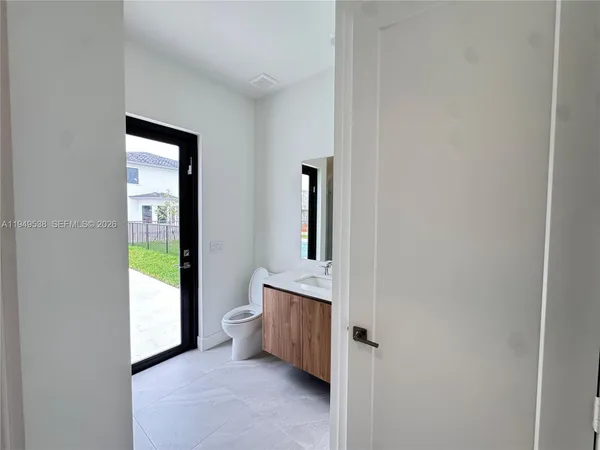 a bathroom with a granite countertop toilet a sink and mirror