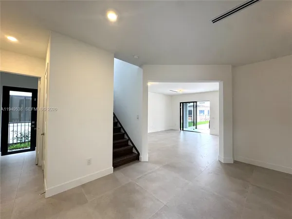 an empty room with windows and stairs