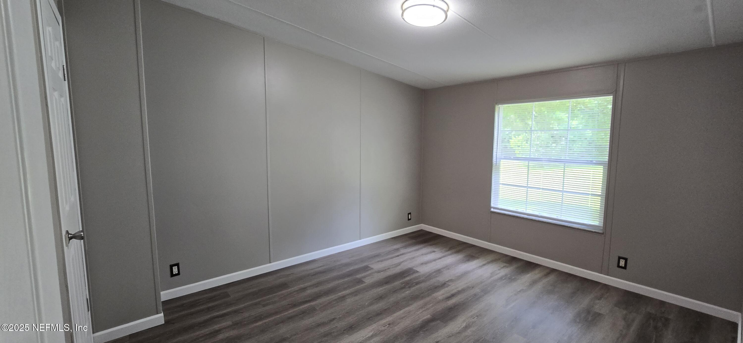 45028 Musslewhite Road Callahan, FL 32011 - Photo 17 of 18 a view of an empty room with wooden floor and a window