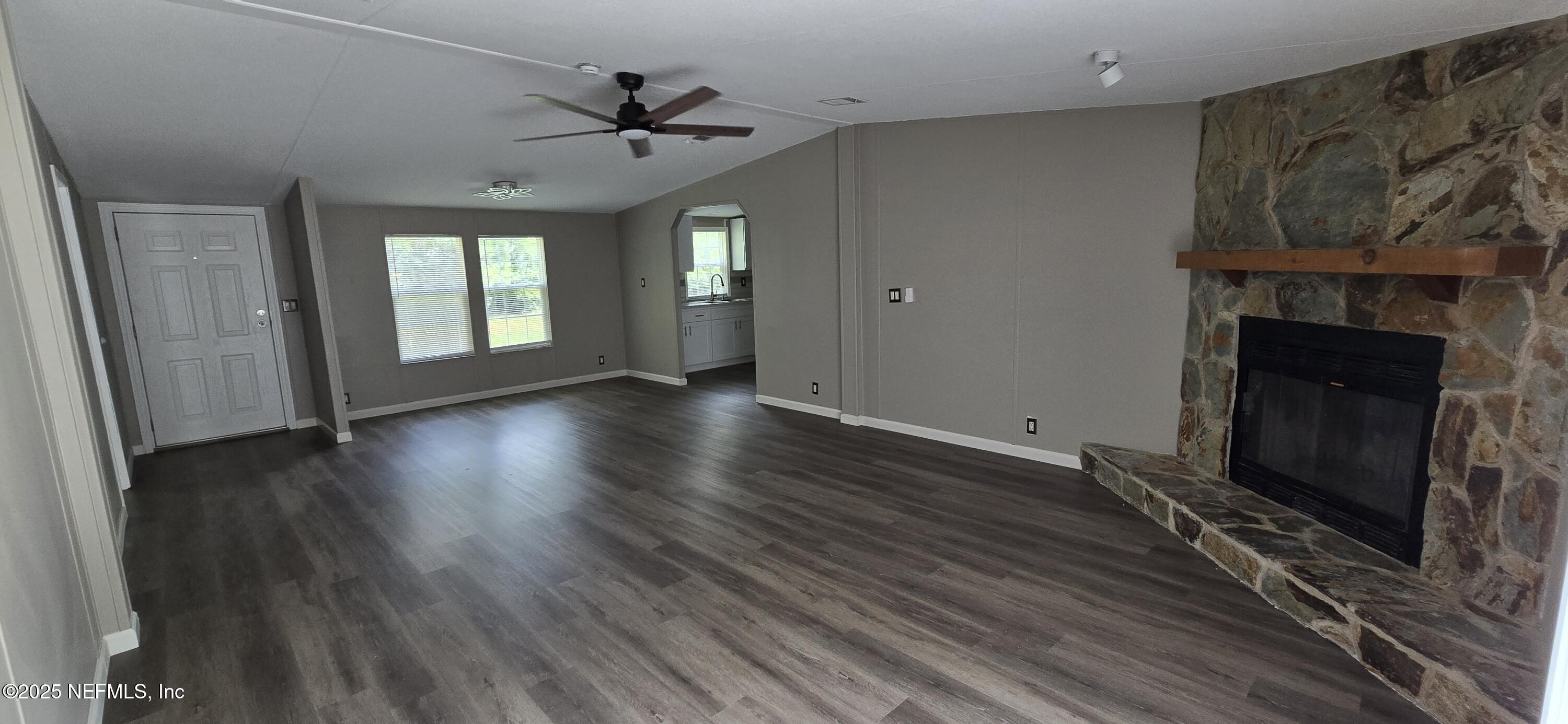 45028 Musslewhite Road Callahan, FL 32011 - Photo 5 of 18 a view of an empty room with wooden floor fireplace and a window