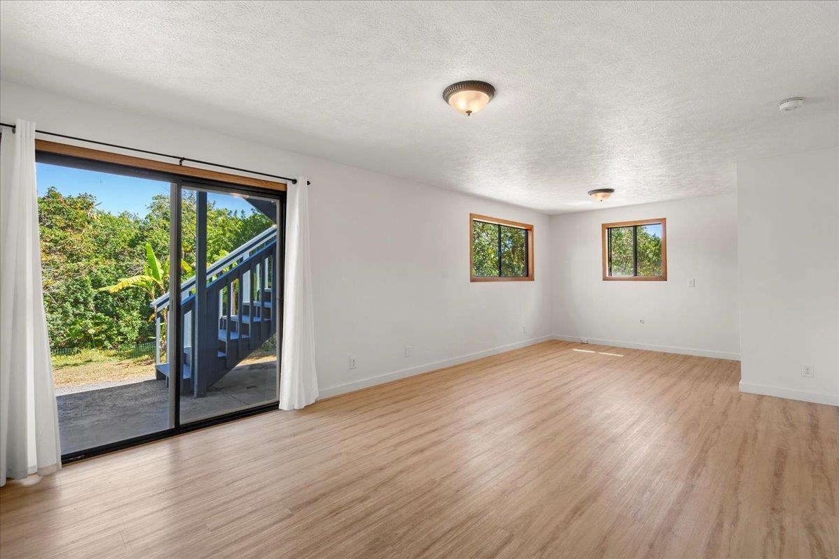 2130 Kauhikoa Road, Unit A Haiku, HI 96708 - Photo 24 of 43 an empty room with wooden floor and windows