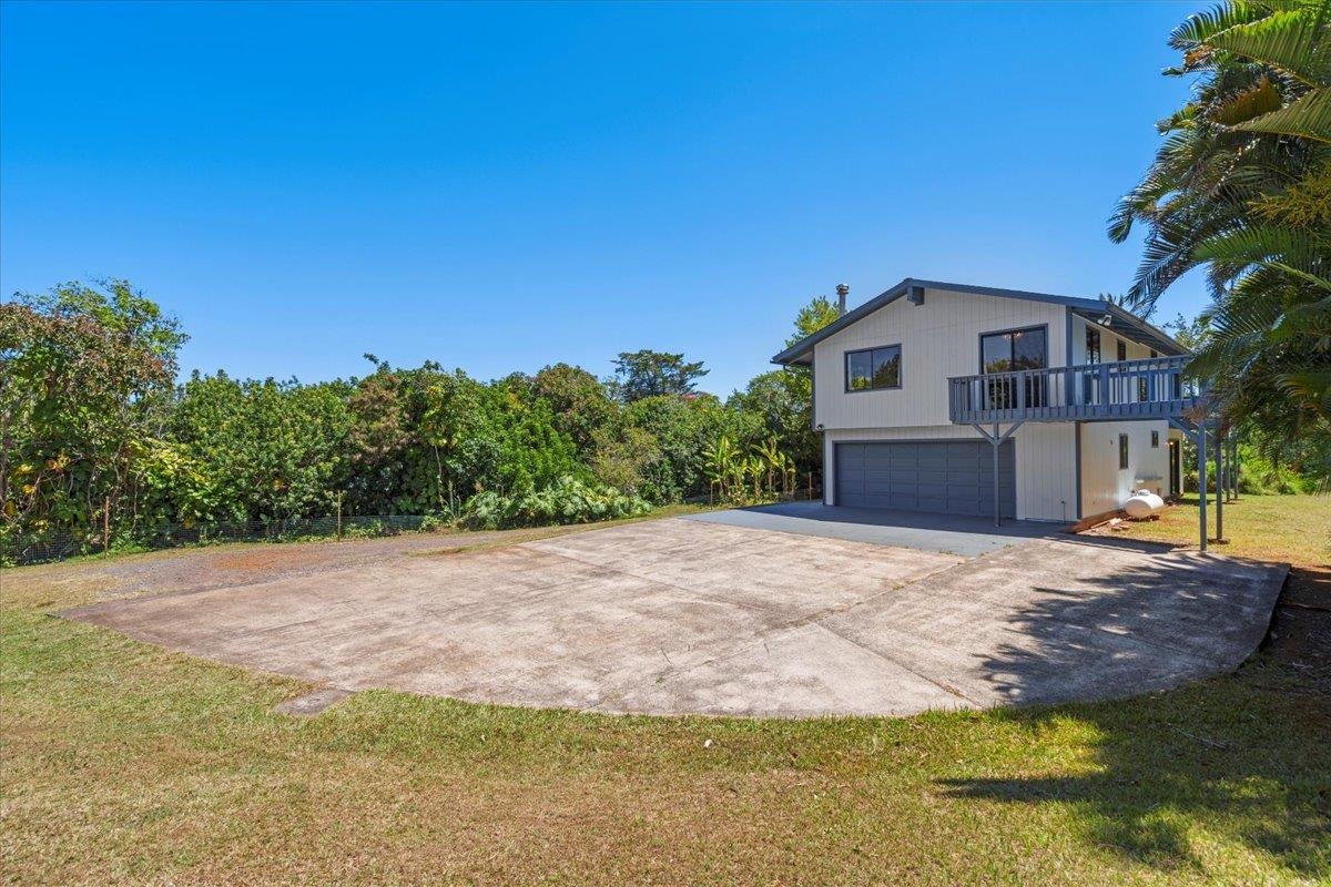 2130 Kauhikoa Road, Unit A Haiku, HI 96708 - Photo 3 of 43 a front view of a house with a yard and garage