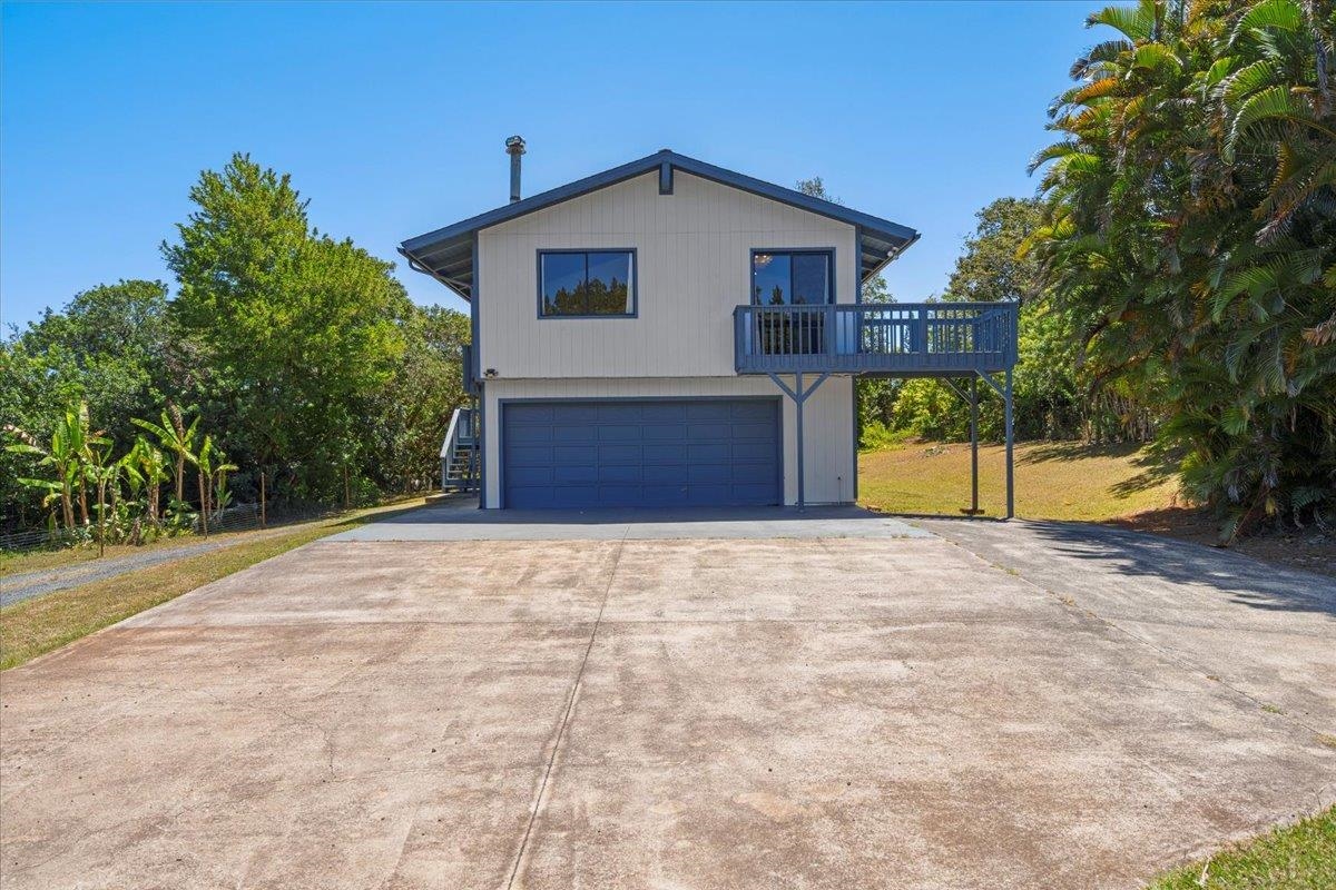 2130 Kauhikoa Road, Unit A Haiku, HI 96708 - Photo 35 of 43 a front view of a house with a yard and garage