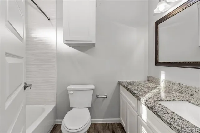 a bathroom with a granite countertop sink toilet and shower