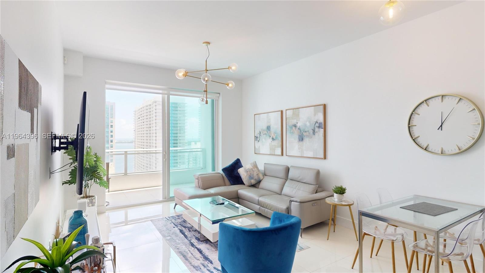 1080 Brickell Avenue, Unit 2804 Miami, FL 33131 - Photo 2 of 35 a living room with furniture a window and a chandelier