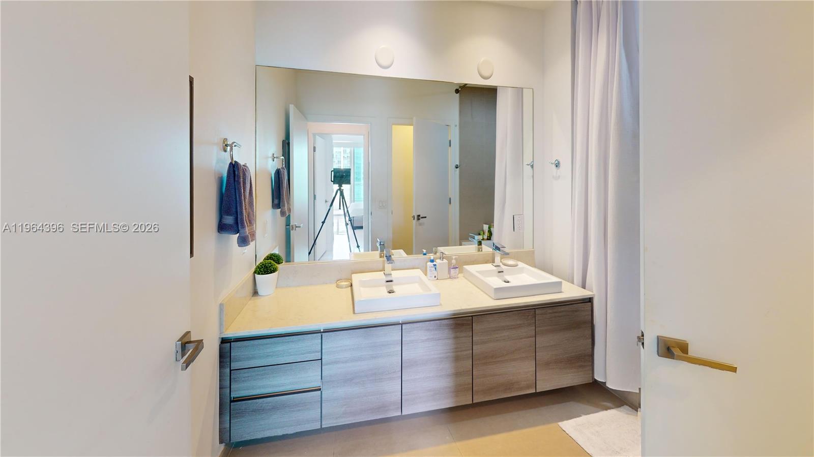 1080 Brickell Avenue, Unit 2804 Miami, FL 33131 - Photo 26 of 35 a bathroom with a sink and a mirror