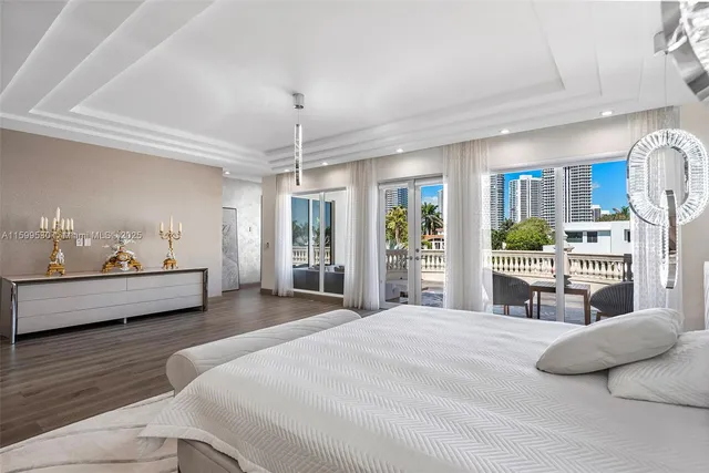 a bedroom with a large bed and a chandelier