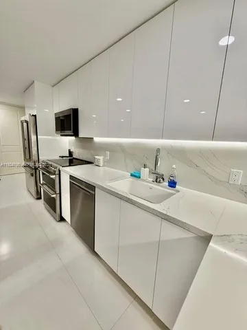a kitchen with stainless steel appliances a sink and a refrigerator