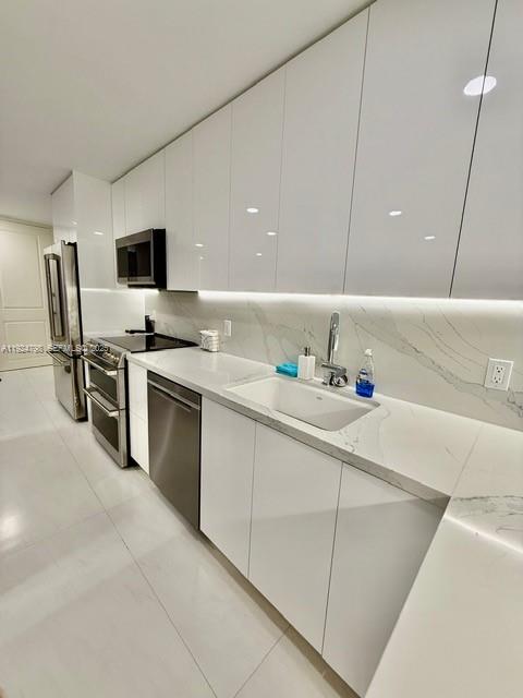 1100 Alton Road, Unit 4D Miami Beach, FL 33139 - Photo 5 of 39 a kitchen with stainless steel appliances a sink and a refrigerator