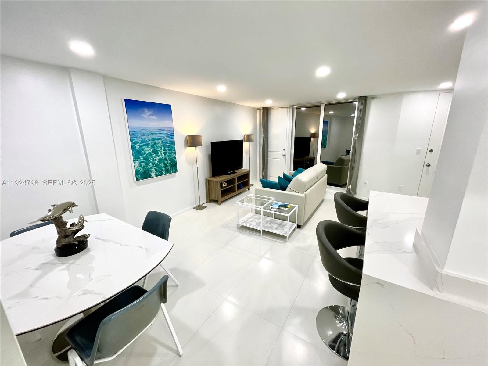 1100 Alton Road, Unit 4D Miami Beach, FL 33139 - Photo 9 of 39 a living room with furniture and a flat screen tv