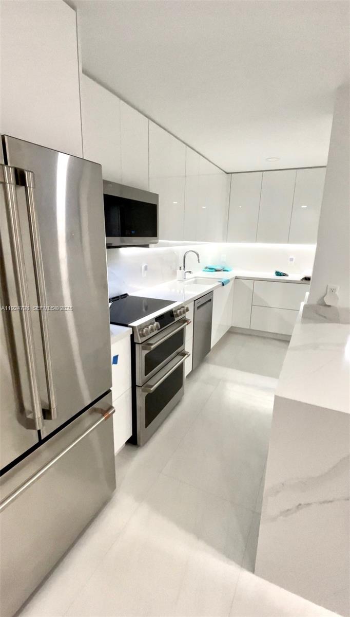1100 Alton Road, Unit 4D Miami Beach, FL 33139 - Photo 10 of 39 a kitchen with a refrigerator sink and stove