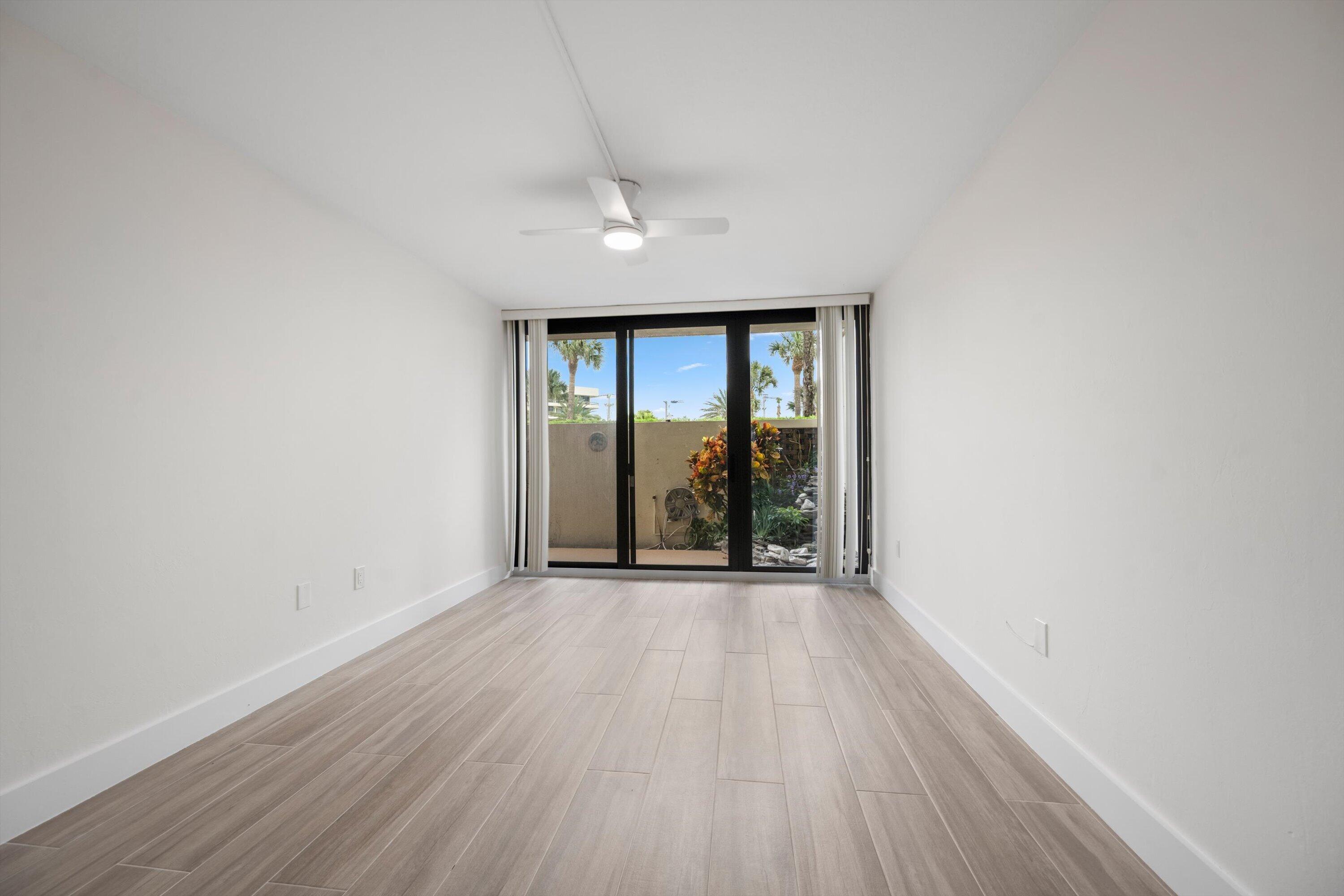 225 South Beach Road, Unit 102 Jupiter, FL 33469 - Photo 17 of 22 an empty room with wooden floor and windows