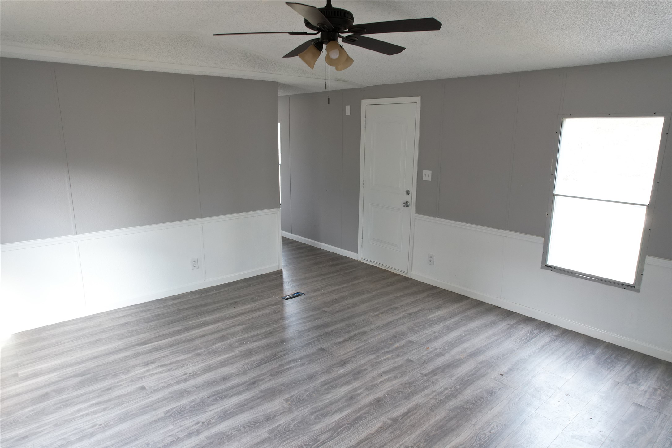 16428 Jireh Road Conroe, TX 77306 - Photo 5 of 25 an empty room with wooden floor fan and windows