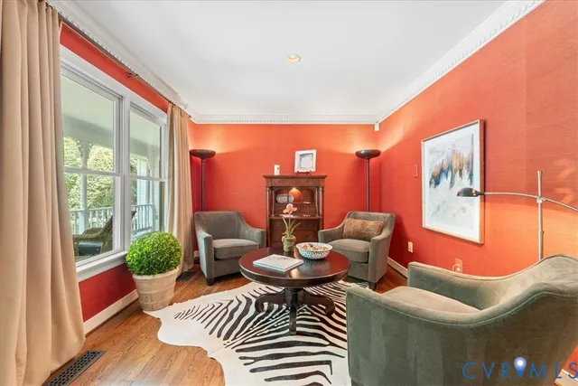 a dining room with furniture a chandelier and wooden floor