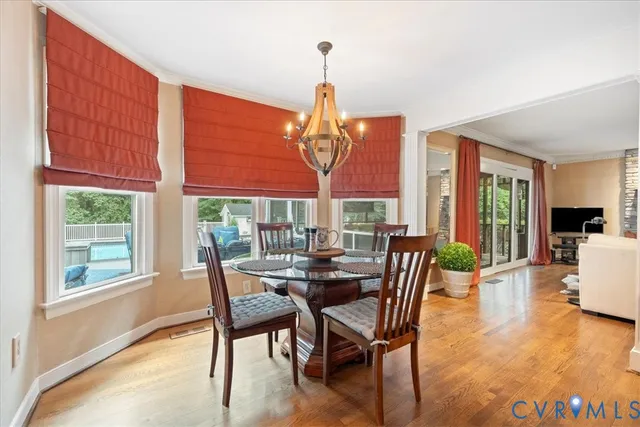 a view of a hallway with wooden floor windows and a dining room