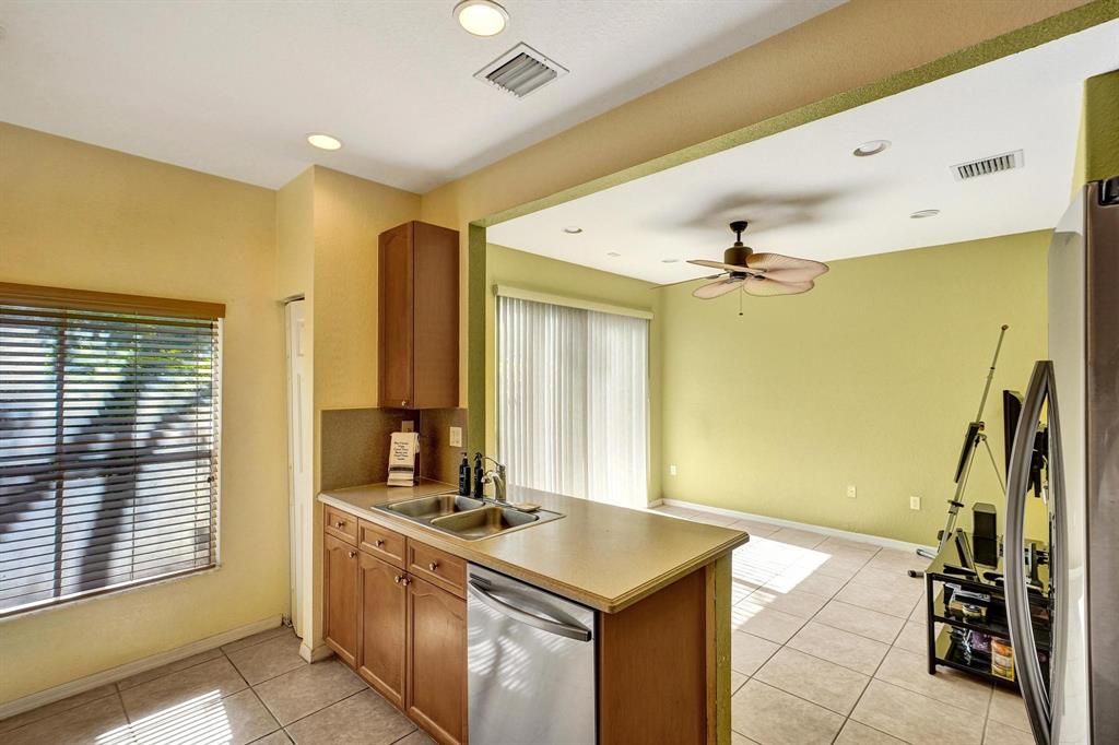 3303 Merrick Lane, Unit 1002 Margate, FL 33063 - Photo 25 of 33 a kitchen with stainless steel appliances granite countertop a sink and a refrigerator